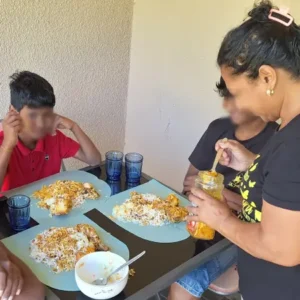 Tamar House residents enjoying a bring-and-share lunch with volunteers serving a hearty meal.