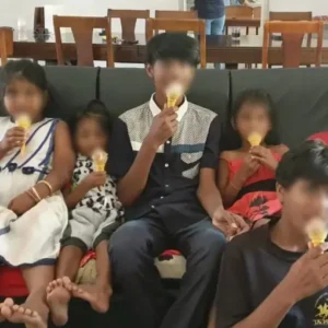 Children at Tamar House sitting together on a couch enjoying ice cream cones.