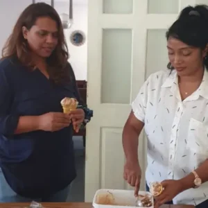 Volunteer scooping ice cream into a cone during a fun activity at Tamar House.